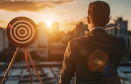 Business professional aiming at target, symbolizing vision and goal achievement – HLK Group