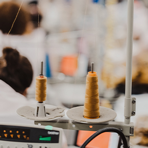 Close-up of sewing threads in garment factory, reflecting HLK Industries’ commitment to sustainability and eco-friendly fashion production.